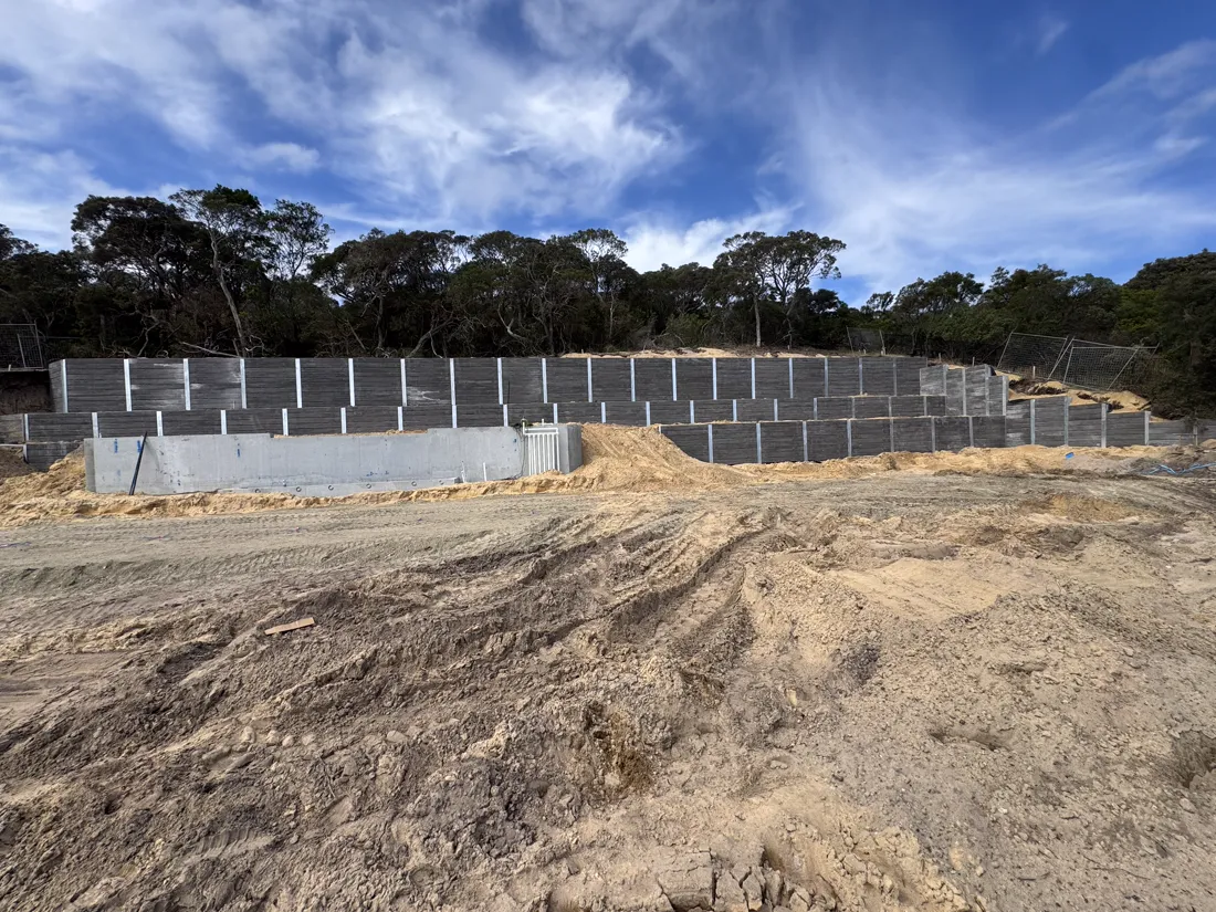 Large multi-tier concrete block retaining wall on a commercial earthworks site